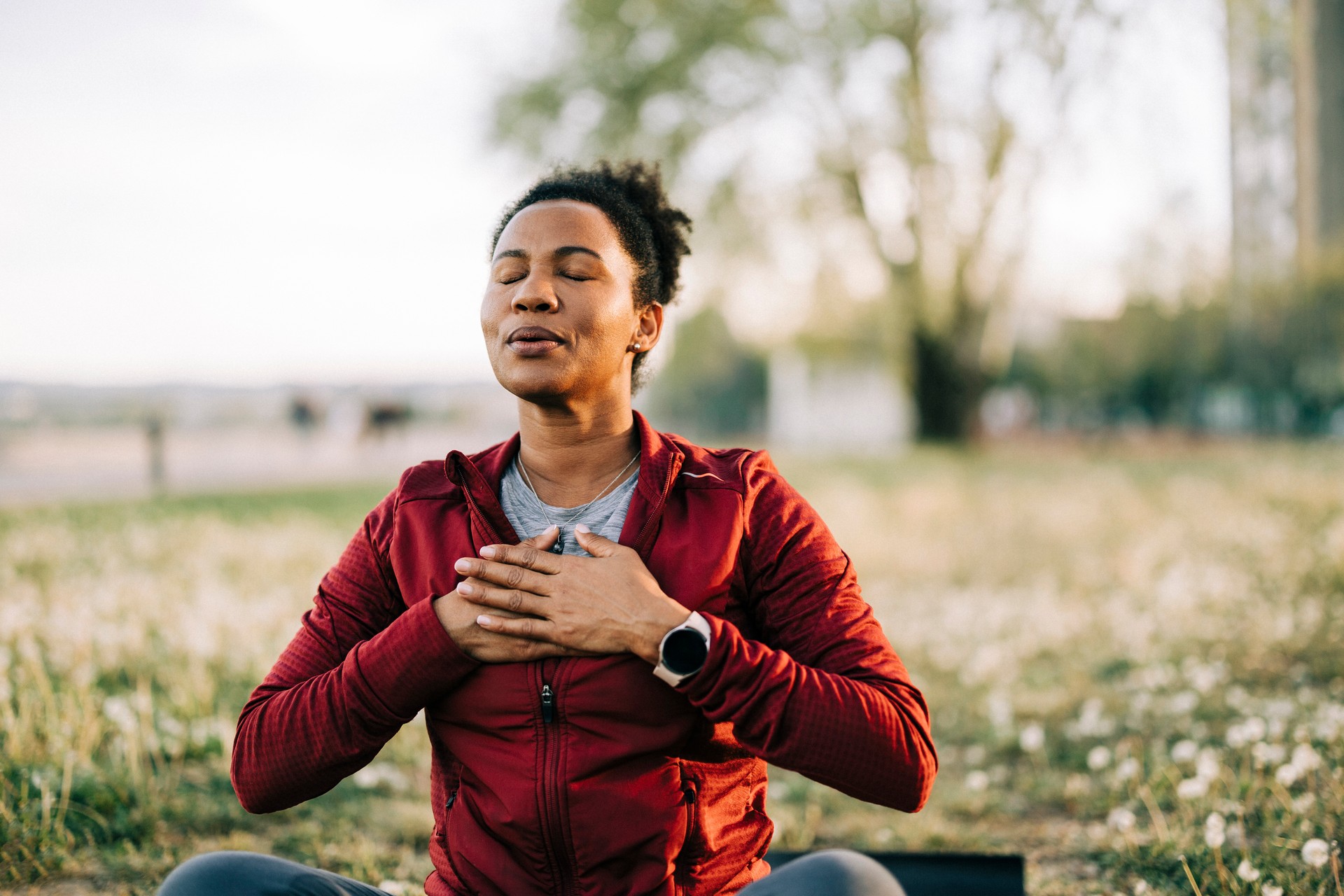 Black woman, breath and hand on chest, for meditation and wellness being peaceful to relax. Bokeh, African American female and lady outdoor, in nature and being calm for breathing exercise and health